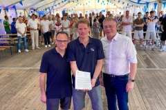 Der große Umschlag: Rafael Tajuelo (v.l.) und Jochen Niebuhr nehmen den Bescheid zum neuen Kunstrasen von Bürgermeister Andreas Hüffmann entgegen.